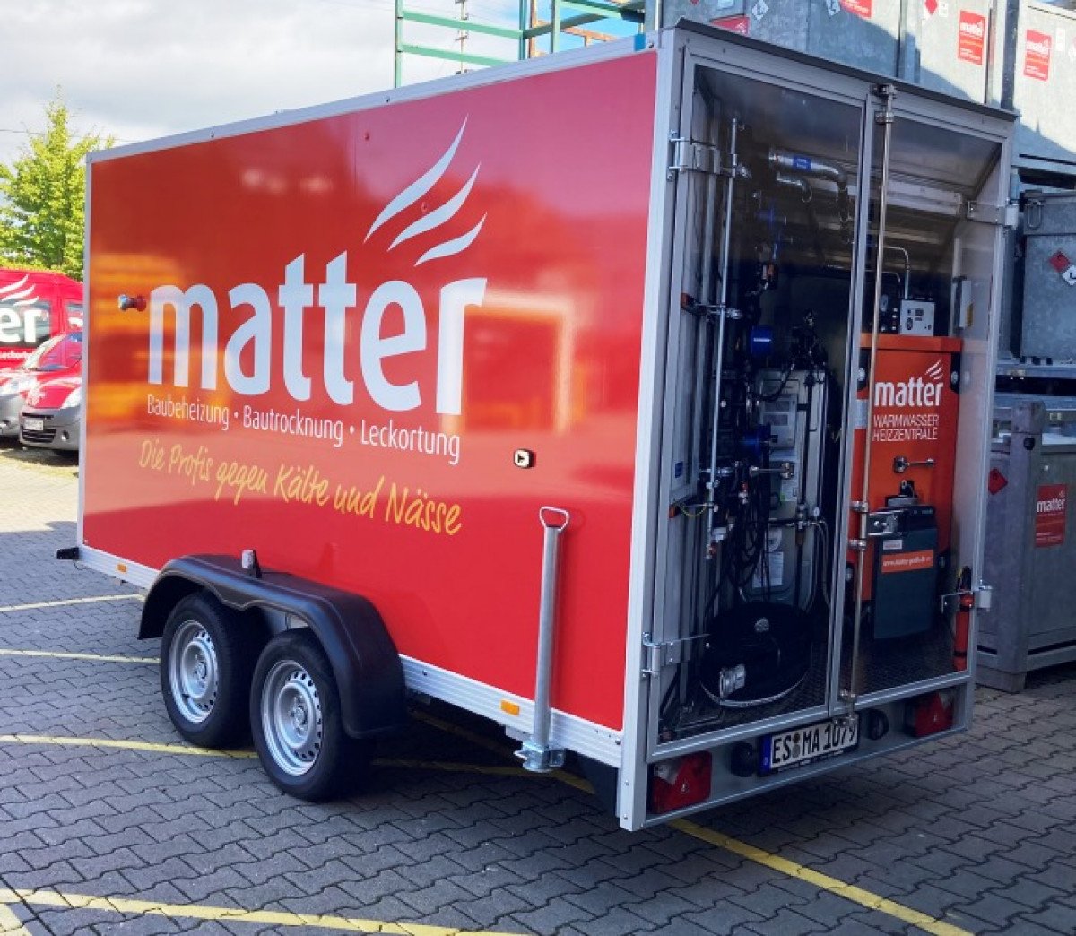 1. Ein Heizmobil mit der Aufschrift "Matter" steht vor einem Gebäude geparkt.
